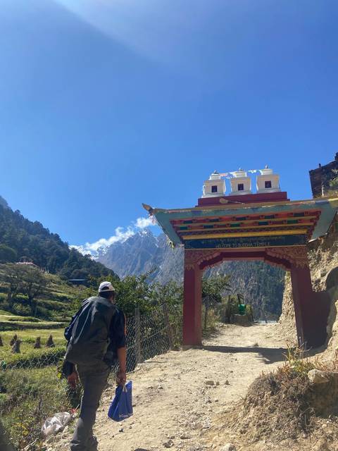       Entrance to a Buddhist temple with mountains in the background.
  