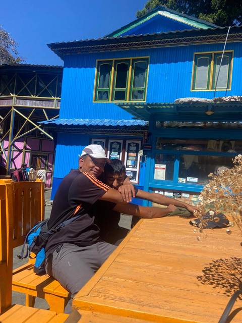 Two men sitting in a colorful building setting.