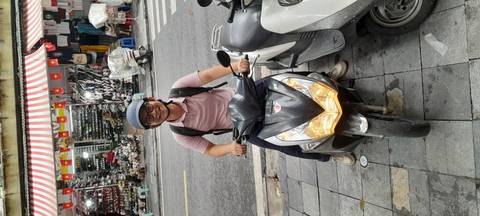 Person sitting on a motorcycle on a busy street.