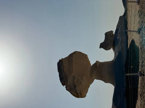 Rock formations against a bright sky in a desert.
