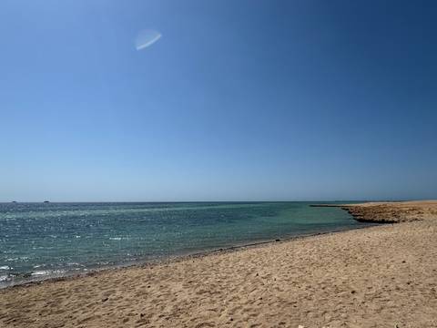       Beach with clear waters and rocky shoreline.
  