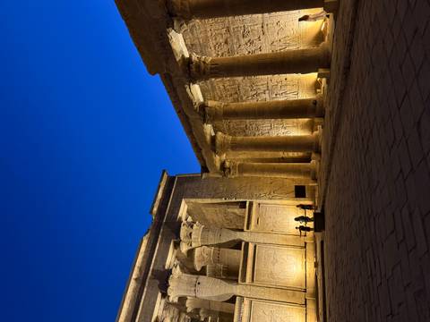 Edfu Temple illuminated at night with ancient columns.