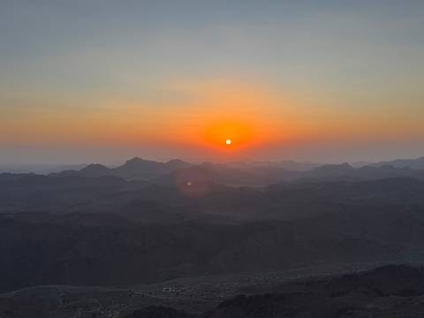 Sunset over mountain range silhouette.