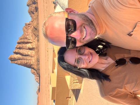 Couple posing in front of sandstone rock formations in the desert.