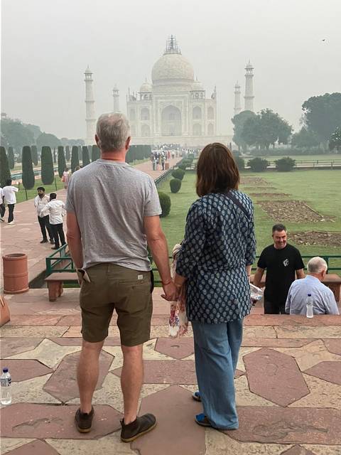 Couple holding hands looking at a distant monument.