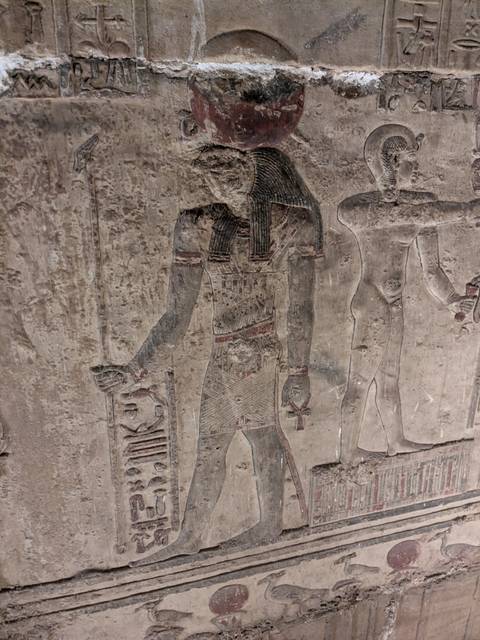 Ancient Egyptian wall with vivid hieroglyphics and artwork.