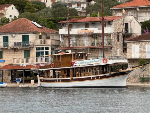       Wooden boat in front of modern and traditional buildings.
  