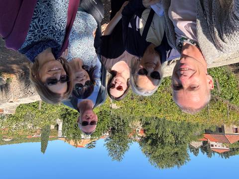       Group of six people posing in a vineyard setting.
  