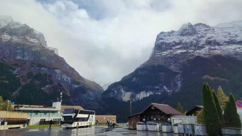 Mountainous landscape with buses in a valley setting.