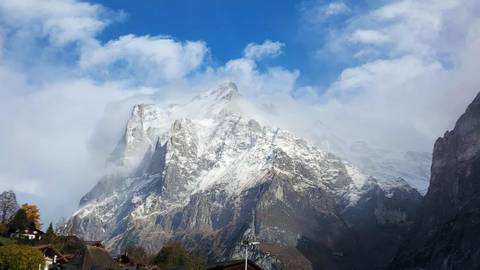 Snow-covered peak with clouds clearing.