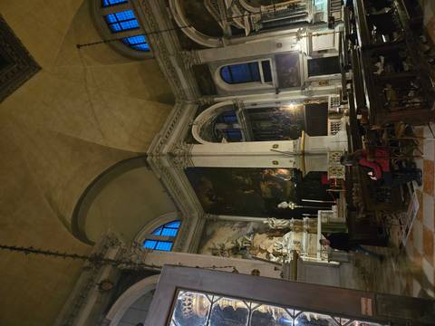 Interior of a dimly lit church with sculptures and paintings.