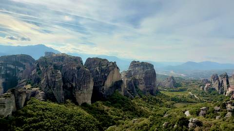       Mountainous landscape with rocky formations and greenery.
  