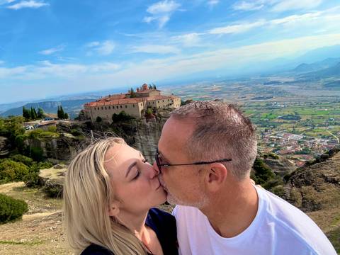       Couple kissing with a scenic landscape in the background.
  