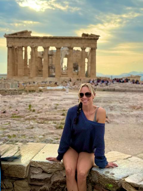       Person posing in front of ancient ruins.
  