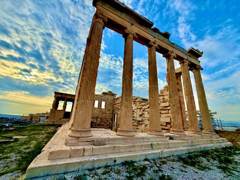       Ancient ruins with columns against a blue sky.
  