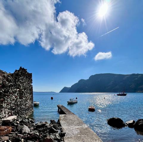 Scenic coastal view with boats and hills.