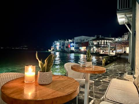 Nighttime coastal view with waterfront cafes.