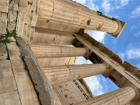       Columns of an ancient temple under a blue sky.
  