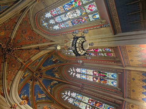       Intricate cathedral ceiling with colorful stained glass windows.
  
