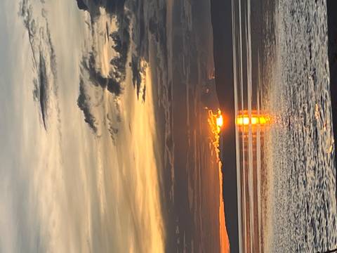 Sunset over the ocean with reflection on the water.