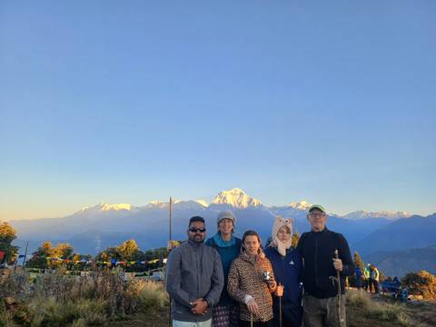       A group of people with a mountain backdrop during sunrise.
  
