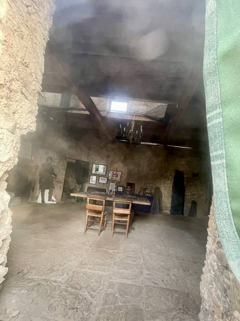 Interior of a rustic stone building with a setup dining table.