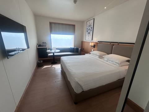 Hotel room interior with a bed and a window.