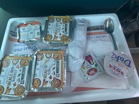       Train meal tray with packaged food and a spoon.
  