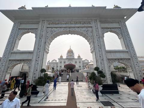       Sikh temple entrance with golden domes in Delhi.
  