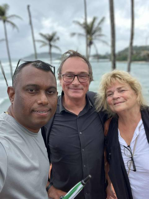 Selfie of three people with water in the background.
