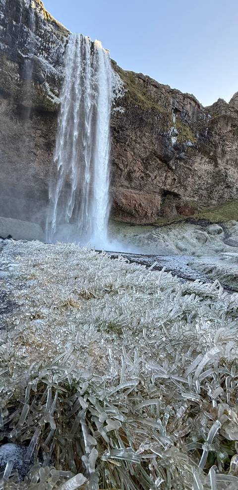 Ice-covered waterfall with frozen landscape.