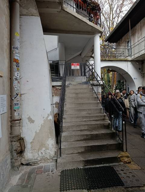 Group of people on a staircase with an urban backdrop.