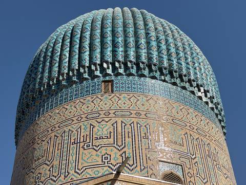       Highly detailed and ornate tiled dome of a building.
  