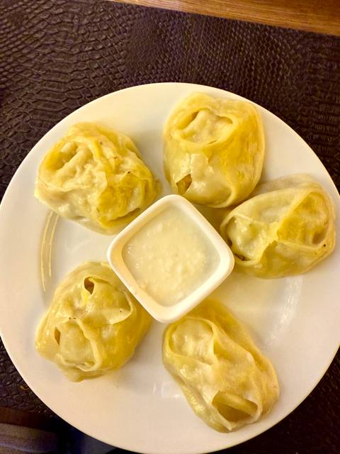       Plate of traditional dumplings with a sauce dip.
  