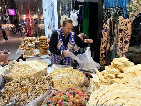       Market vendor displaying various traditional snacks.
  