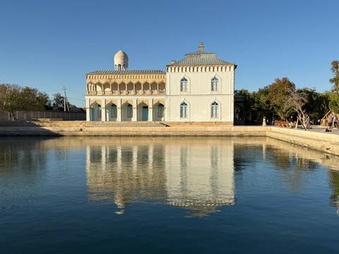       Serene building near a reflective body of water with arches.
  