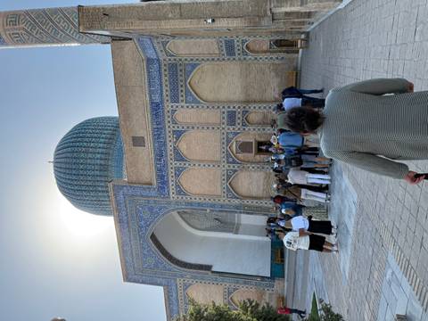       Visitors in line at a detailed architectural site with a large dome.
  
