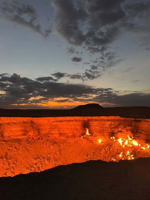 Fiery crater at dusk with a dramatic sky.