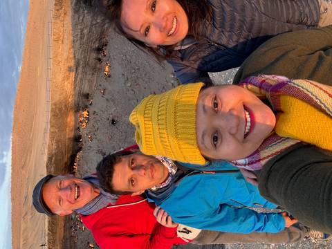 Four people smiling in front of a fiery crater.
