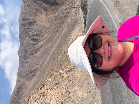       A person taking a selfie with a mountain lake in the background.
  