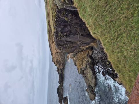 Rugged rocky coastline with ocean waves.
