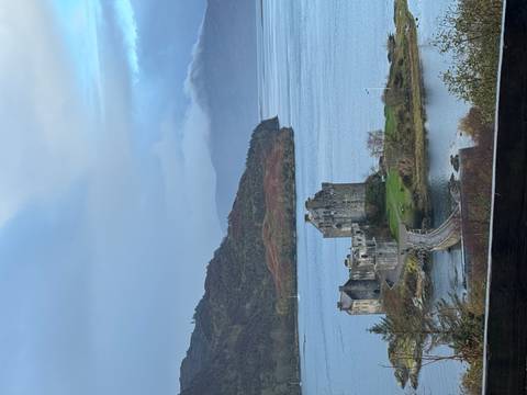       Scenic view of Eilean Donan Castle on a day with dramatic clouds.
  