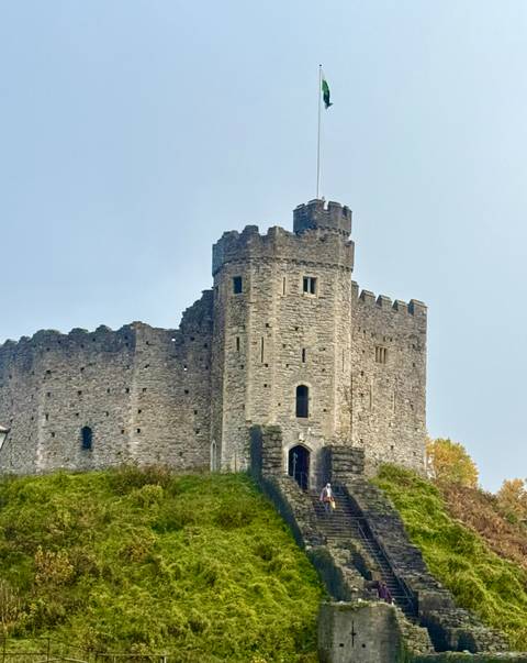 A stone castle with towers on a cloudy day.
