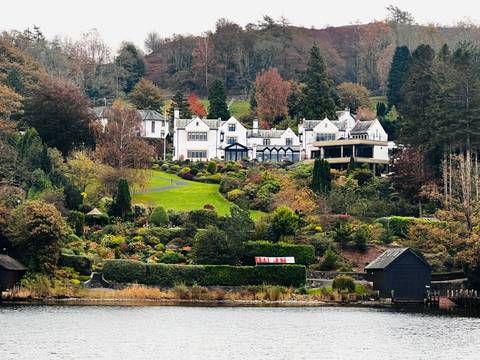 A scenic estate with gardens beside a lake.