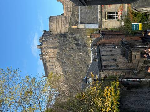 A historic castle atop a hill under a blue sky.