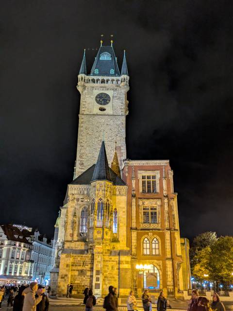 Historic clock tower building lit up at night.