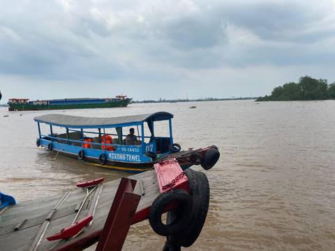 Small motorboat labeled 'Mekong Travel' with people on a river.