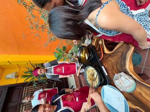 People cooking outdoors with frying pans.