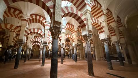 Interior of the Mezquita-Cathedral with distinctive red and white arches.