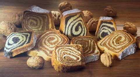       Array of spiral pastries with walnuts on a wooden table.
  